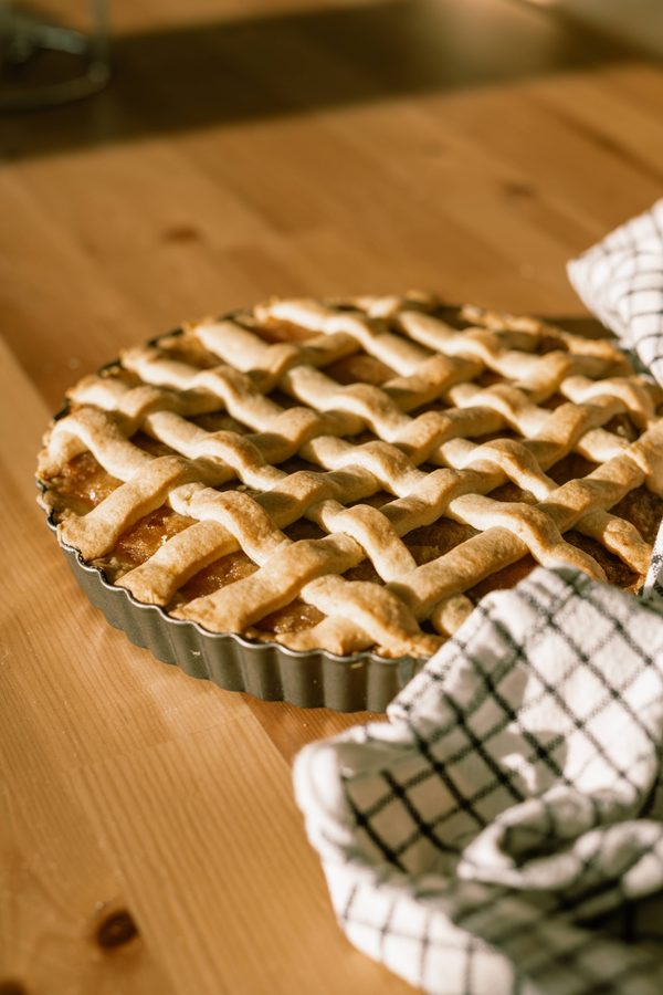 Pastafrola — goudbruine traliewerktaart in een geribbelde vorm op een warme houten tafel